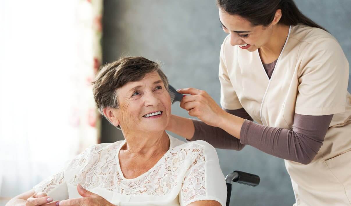 caregiver combing the senior woman's hair