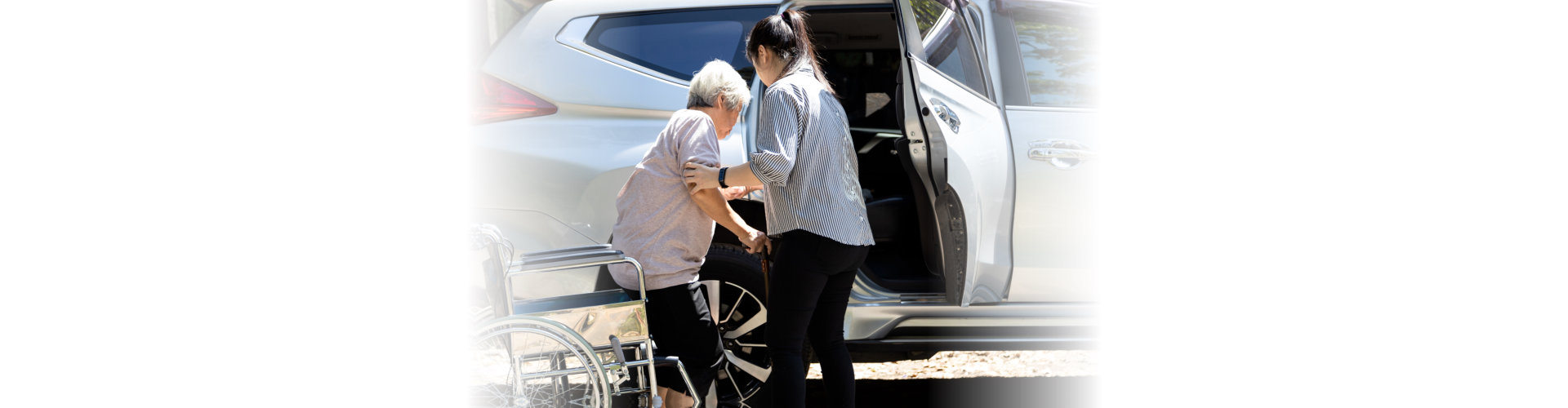 Younger woman assisting elderly woman on a wheelchair